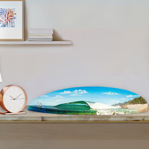 Decorative wall art of a mountain landscape on a shelf with books and a clock.
