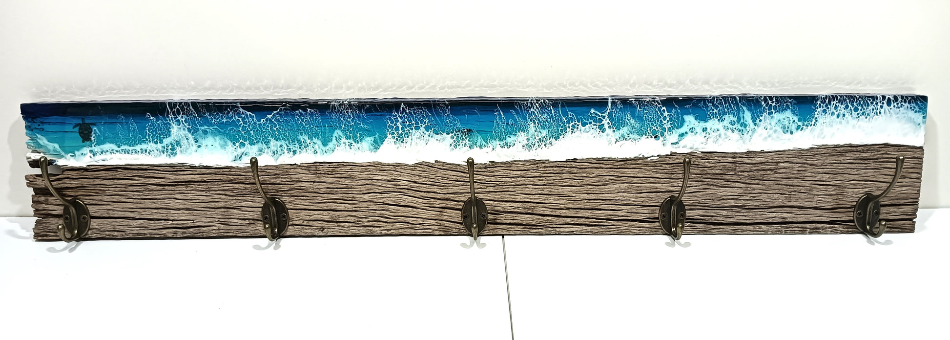 coat rack made form salvaged wood with a deep blue resin ocean. sturdy 95mm antique bronze hooks. 