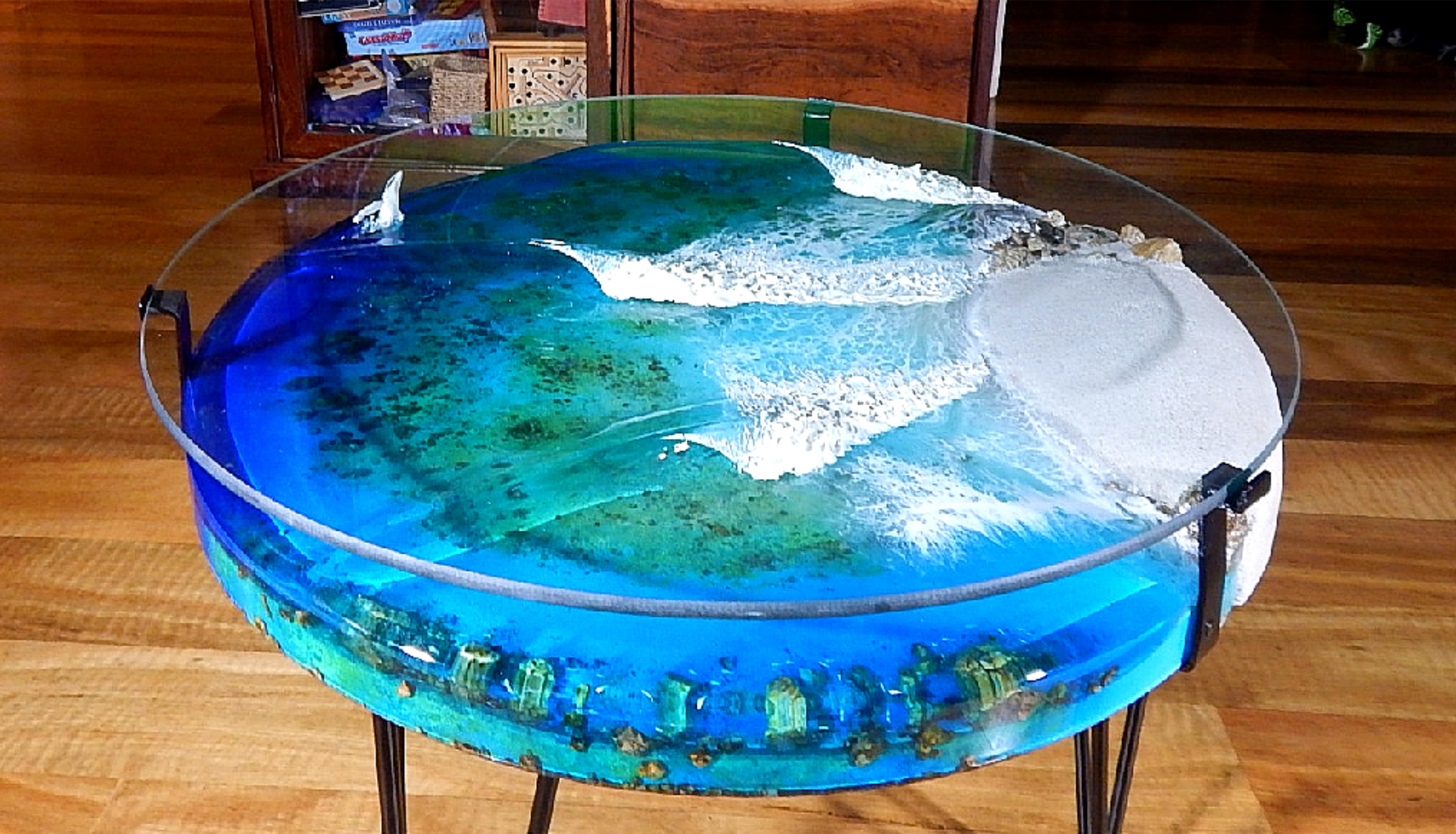 Coffee table resin art with a deep pour resin ocean that depicts fish and a whale breaching. 3D resin waves crash over a hand painted reef.